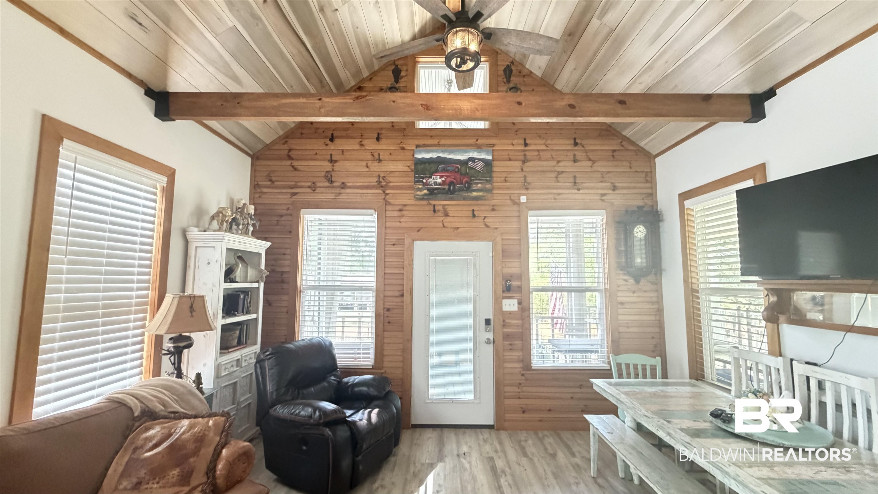 3983 Eureka Landing Road Uriah, AL 36480 - Photo 5 of 45 Living room with light wood-style floors, ceiling fan, plenty of natural light, wooden walls, and a high wood beamed ceiling