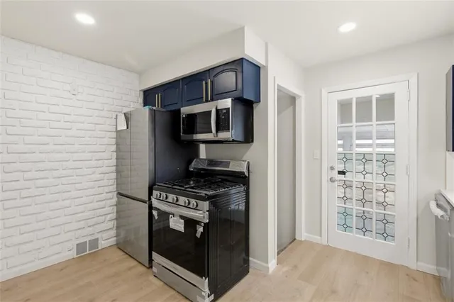 a kitchen with stainless steel appliances a stove a microwave and a refrigerator