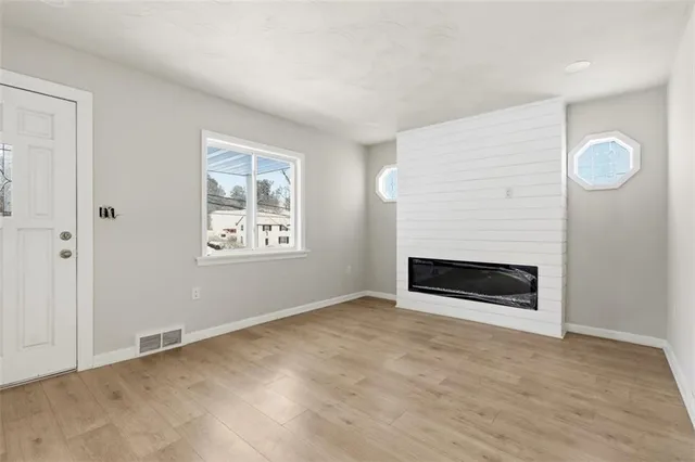 an empty room with fireplace and window