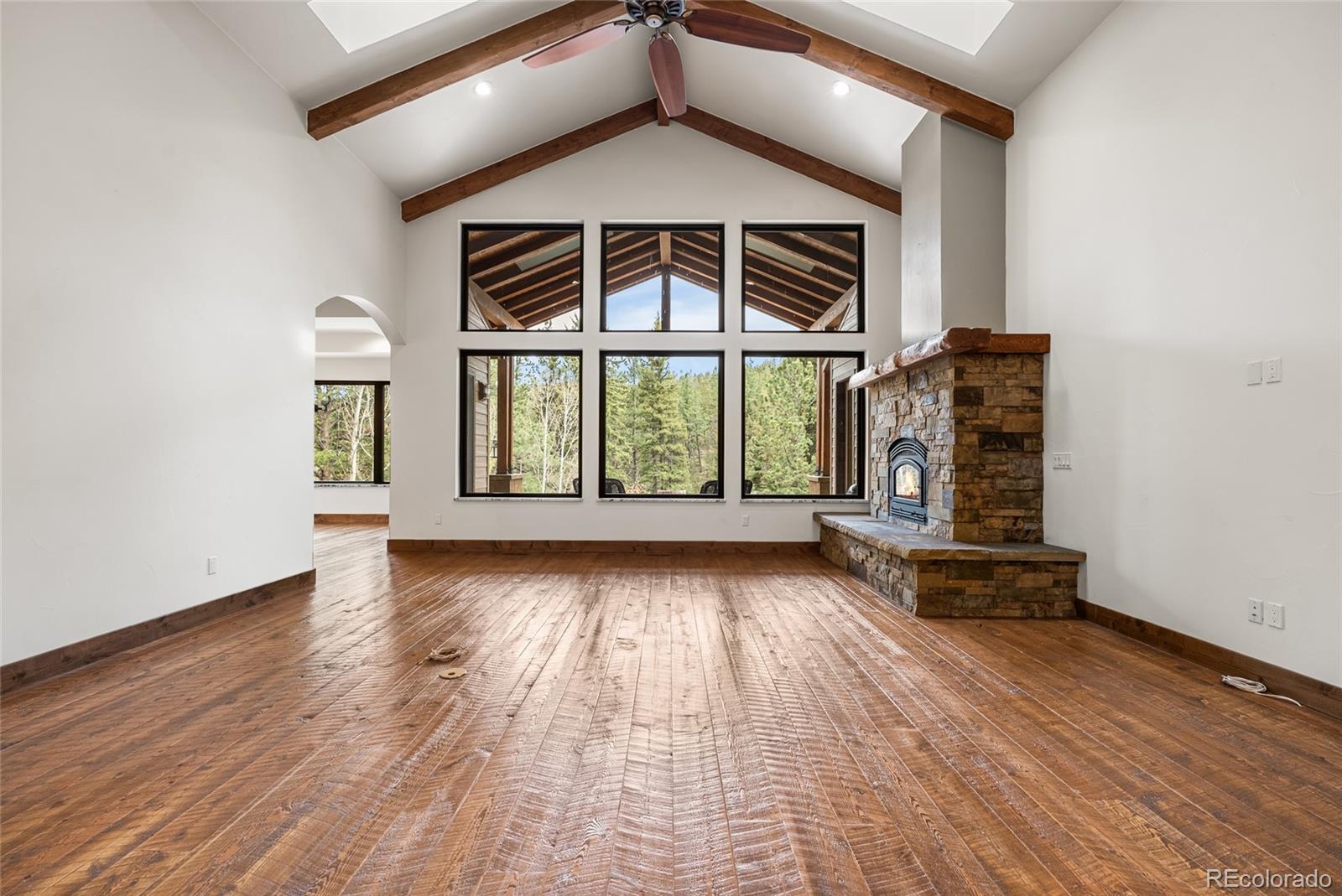 280 Double Tree Road Bailey, CO 80421 - Photo 6 of 43 an empty room with wooden floor and windows
