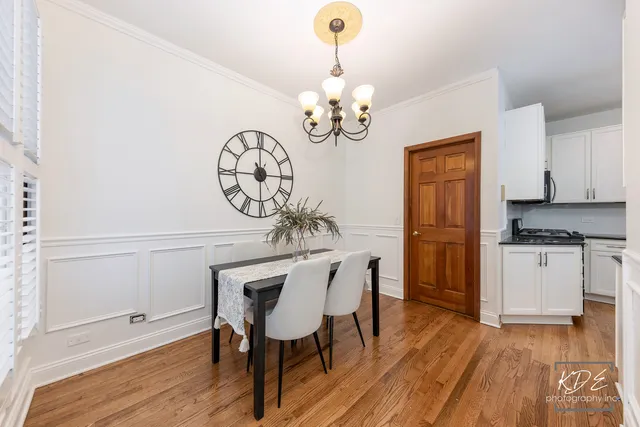 a view of a dining room with furniture a chandelier and wooden floor