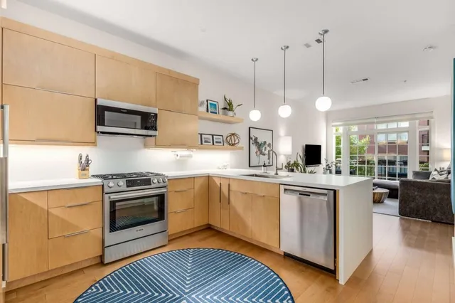 a open kitchen with stainless steel appliances granite countertop a refrigerator a sink and a stove