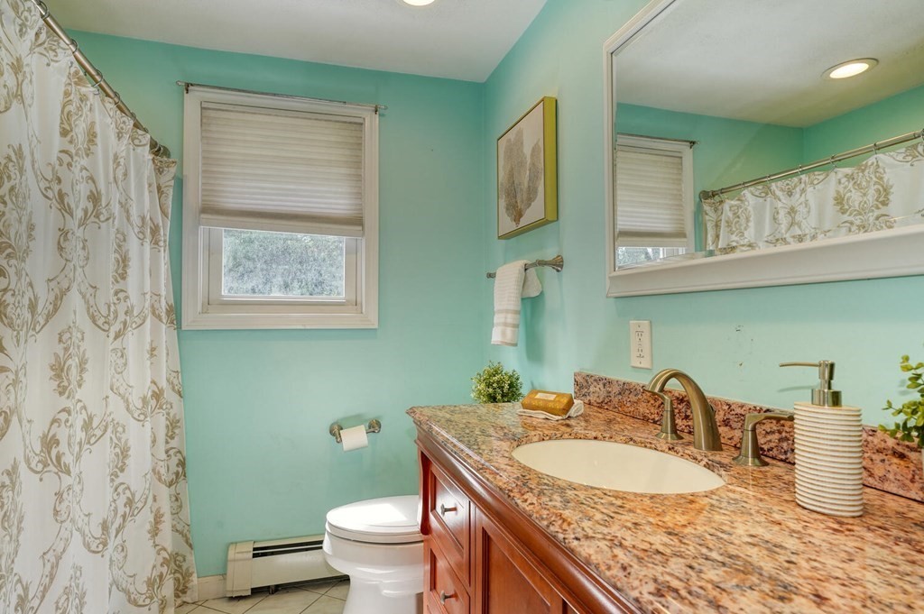 16 Lasallette Road, Unit 16 Billerica, MA 01821 - Photo 15 of 27 a bathroom with a granite countertop toilet sink and mirror