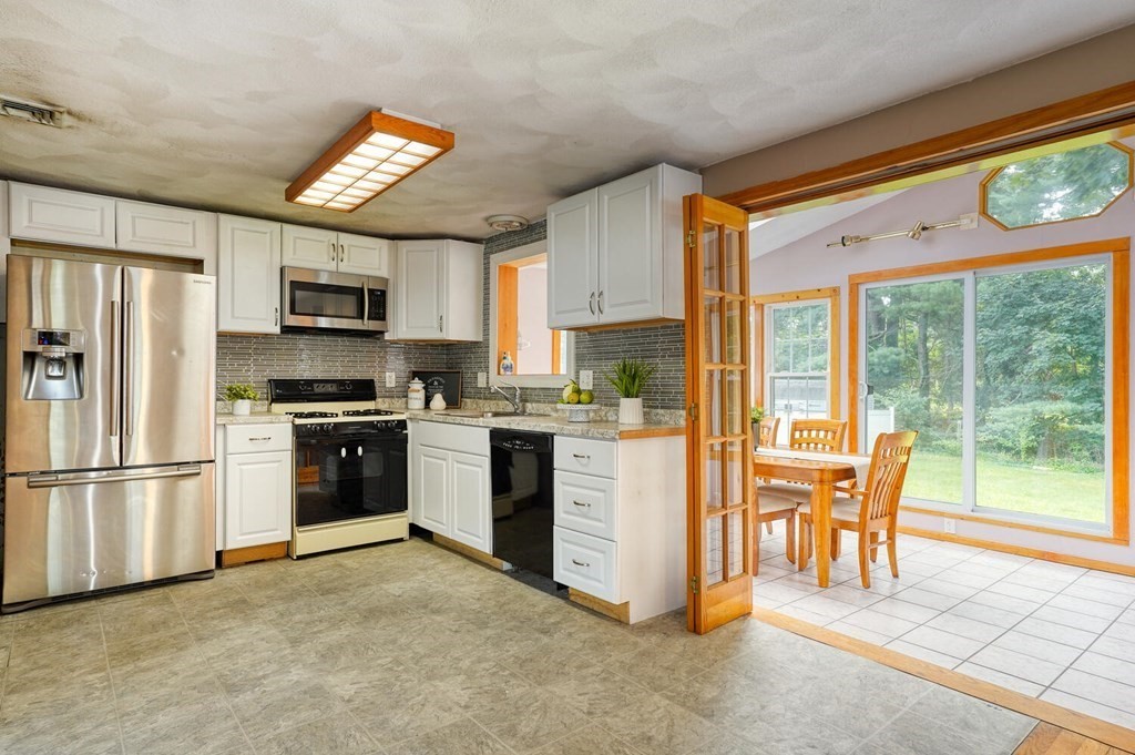 16 Lasallette Road, Unit 16 Billerica, MA 01821 - Photo 8 of 27 a kitchen with stainless steel appliances granite countertop a refrigerator and a stove top oven