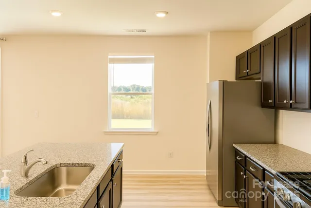 a kitchen with a sink a refrigerator and cabinets