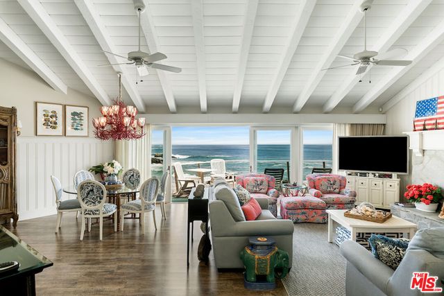 a living room with furniture chandelier and a large window