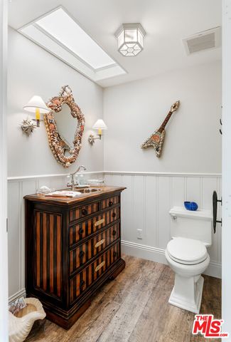 a bedroom with bed and a flat tv screen on dresser