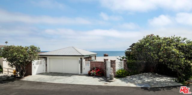 a view of a house with a yard and pathway