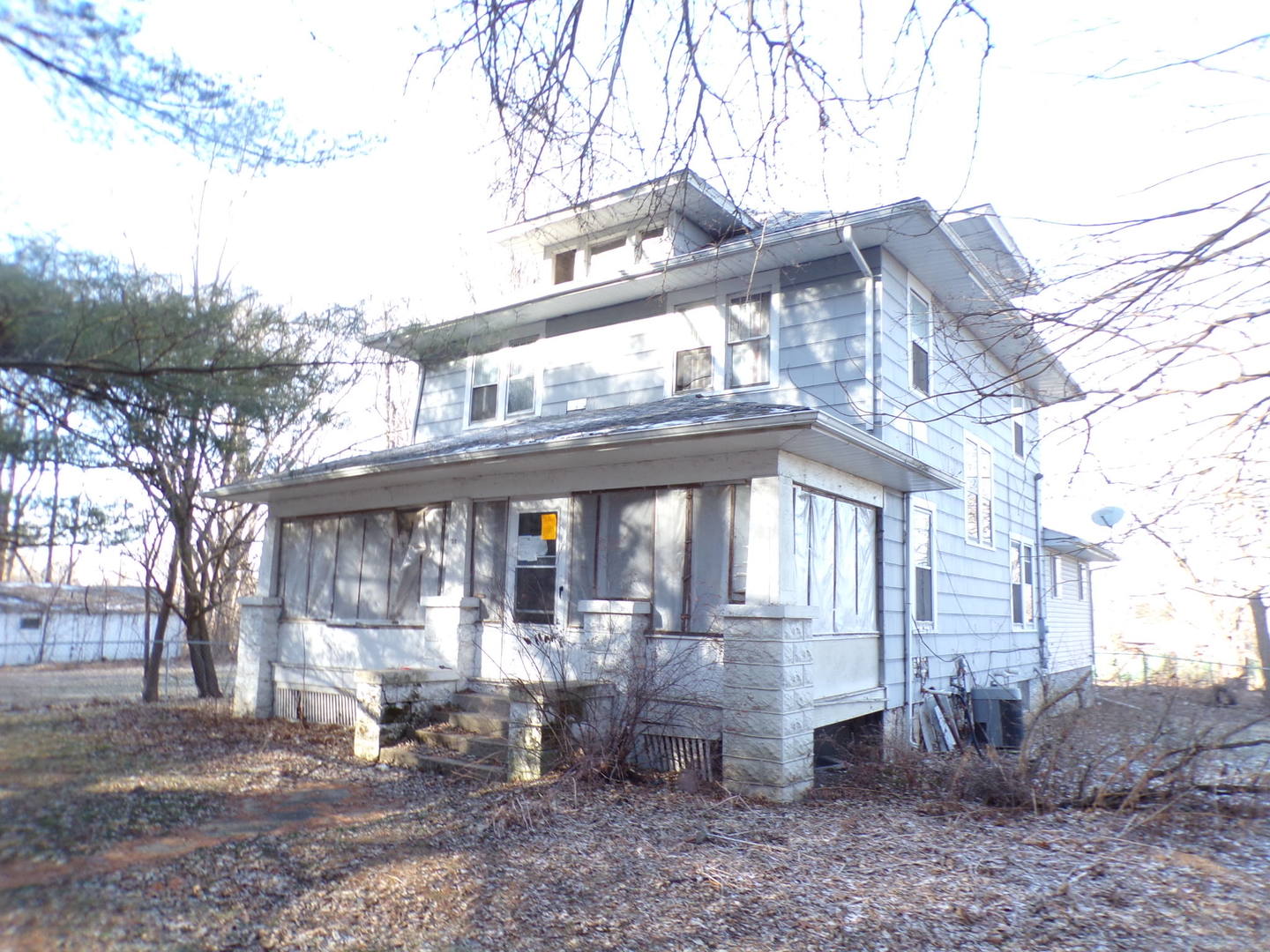 a view of a building with a yard and large tree