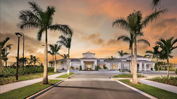 front view of a house with a palm tree