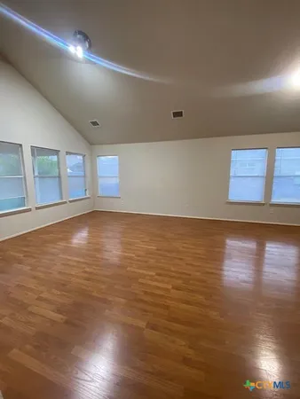 a view of an empty room with wooden floor