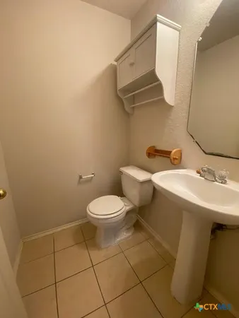 a bathroom with a toilet a sink and mirror