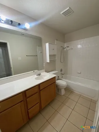 a bathroom with a double vanity sink toilet mirror and shower