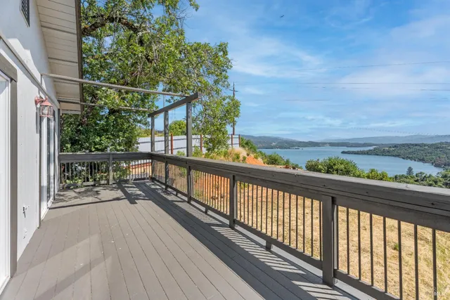 a view of balcony with wooden floor and fence
