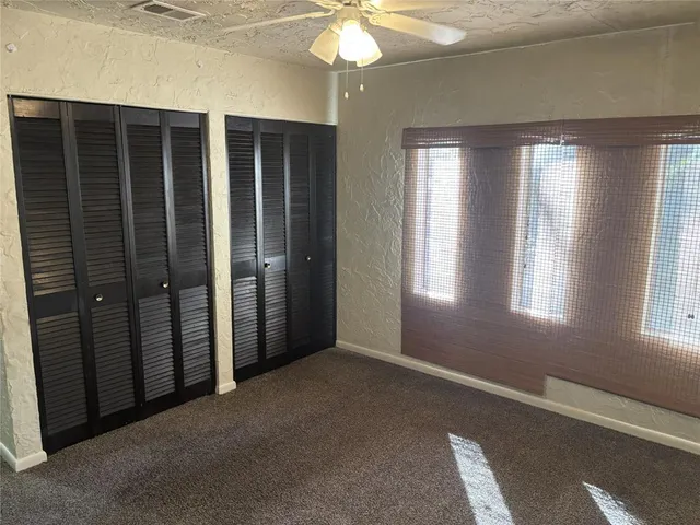 an empty room with windows and closet