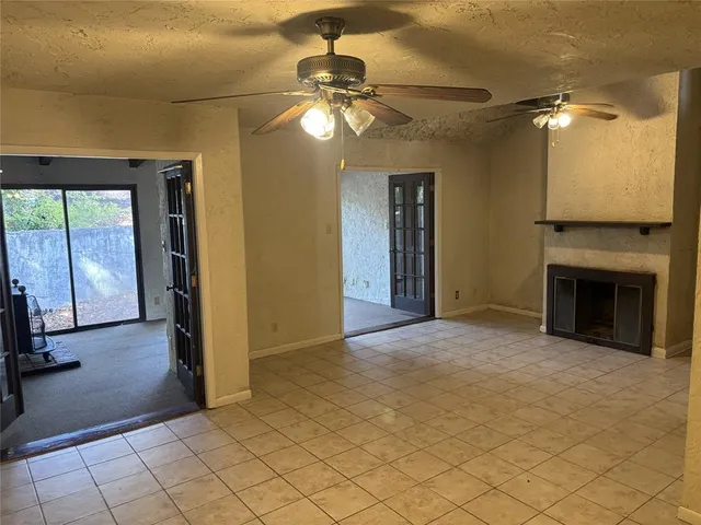 an empty room with fan and windows