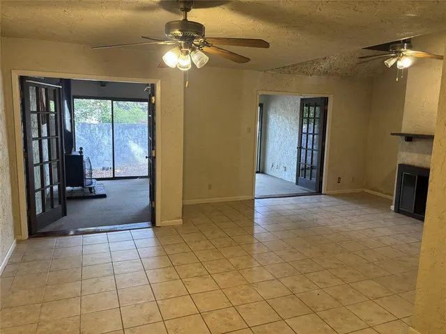 a view of a livingroom with furniture an empty room and chandelier fan