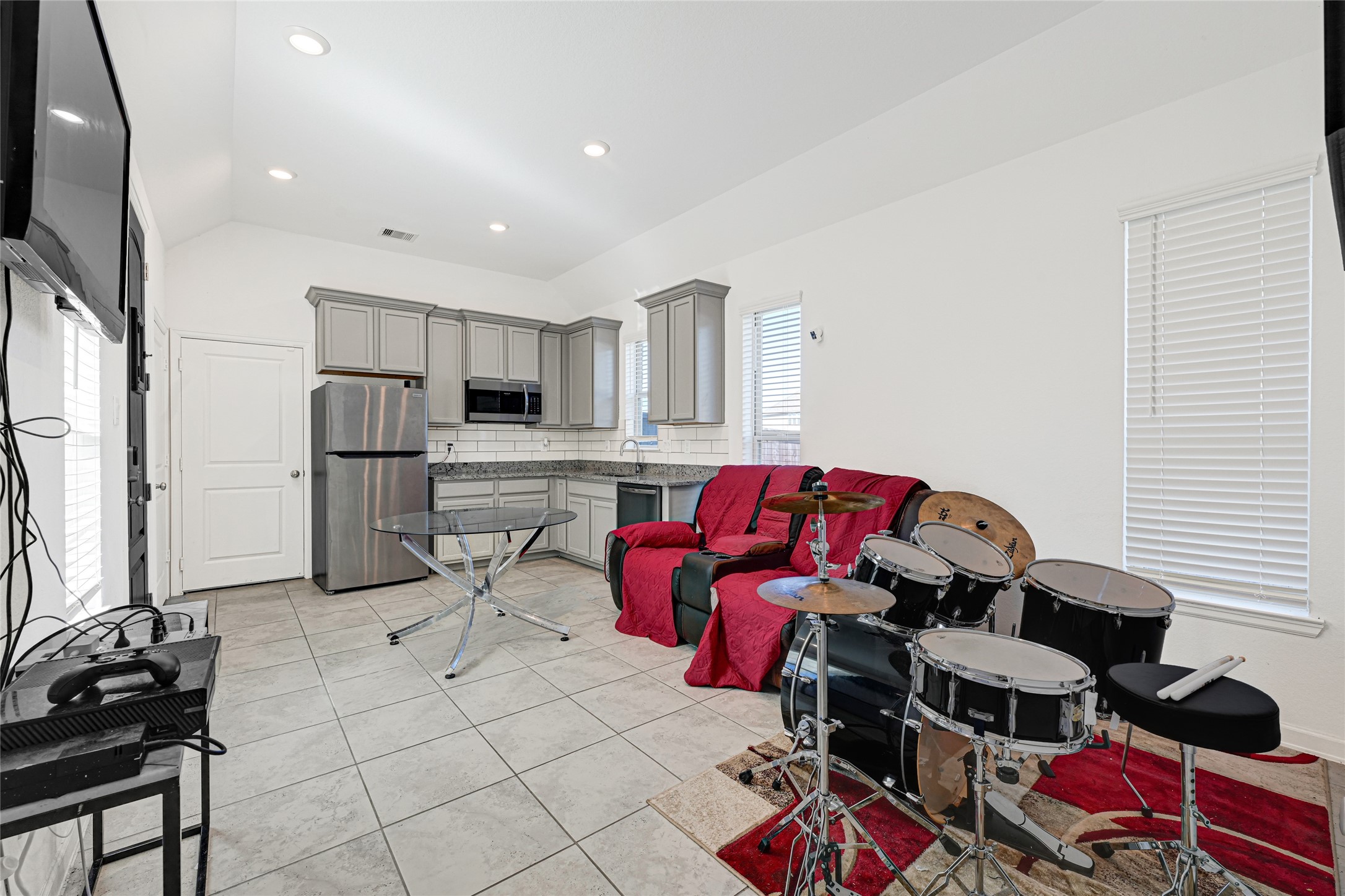 4307 Annandale Lane Rosharon, TX 77583 - Photo 21 of 31 Bright, open-concept living space with modern kitchen featuring gray cabinets and stainless steel appliances is part of the first floor additional private apartment that is a part of this multi-generational primary residence! The space includes room for a cozy seating area and additional seating or eating area. Perhaps even your favorite hobby. Tile flooring and recessed lighting enhance the contemporary feel.