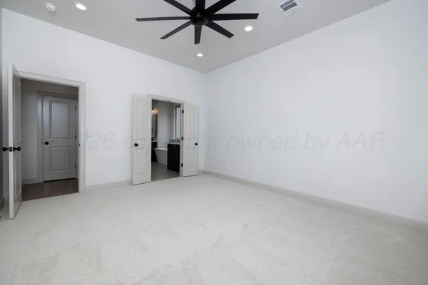 an empty room with closet and a chandelier fan