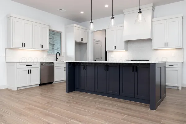 a kitchen with stainless steel appliances granite countertop a sink a stove and a refrigerator