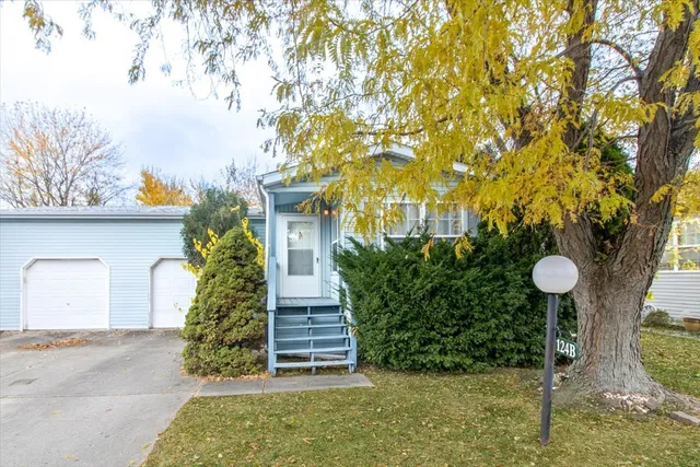 a front view of a house with a yard and tree