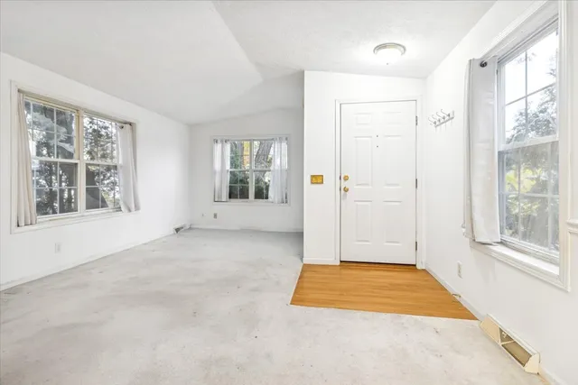 a view of an empty room with window and bathroom