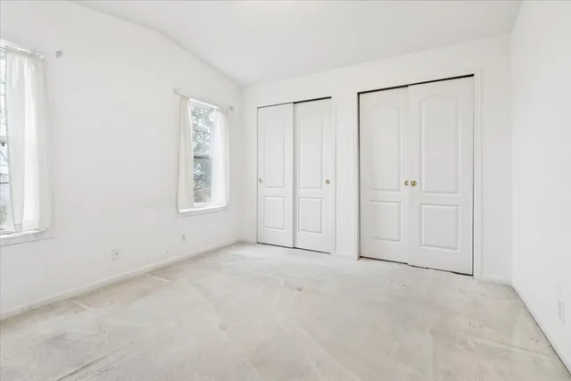 an empty room with windows and closet