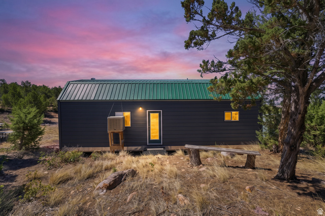 2345 East Frampton Hts Road, Unit 12 Fillmore, UT 84631 - Photo 19 of 31 Dark siding exterior with a green metal roof and an outdoor bench