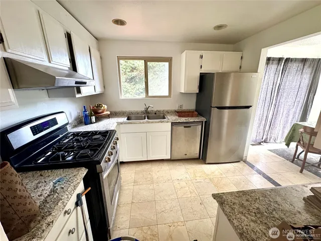 a kitchen with a stove a refrigerator and a sink