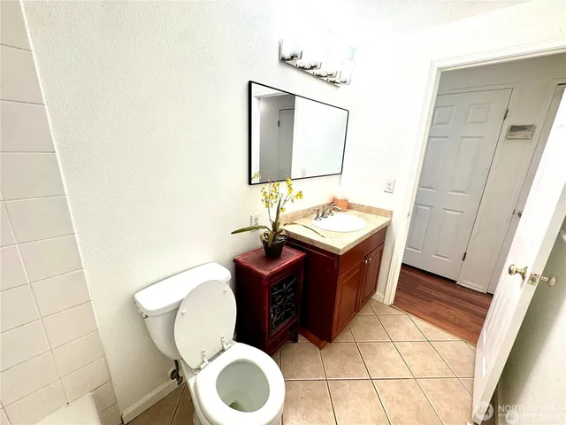 a bathroom with a toilet mirror vanity and sink