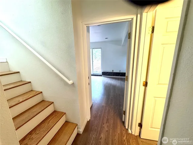 a view of a hallway with wooden floor and staircase