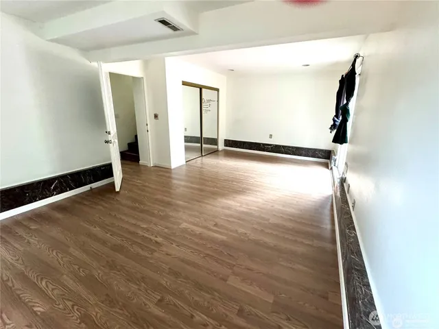 a view of a room with wooden floor