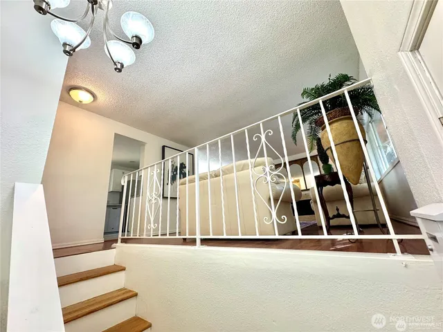 a view of staircase with railing and white walls