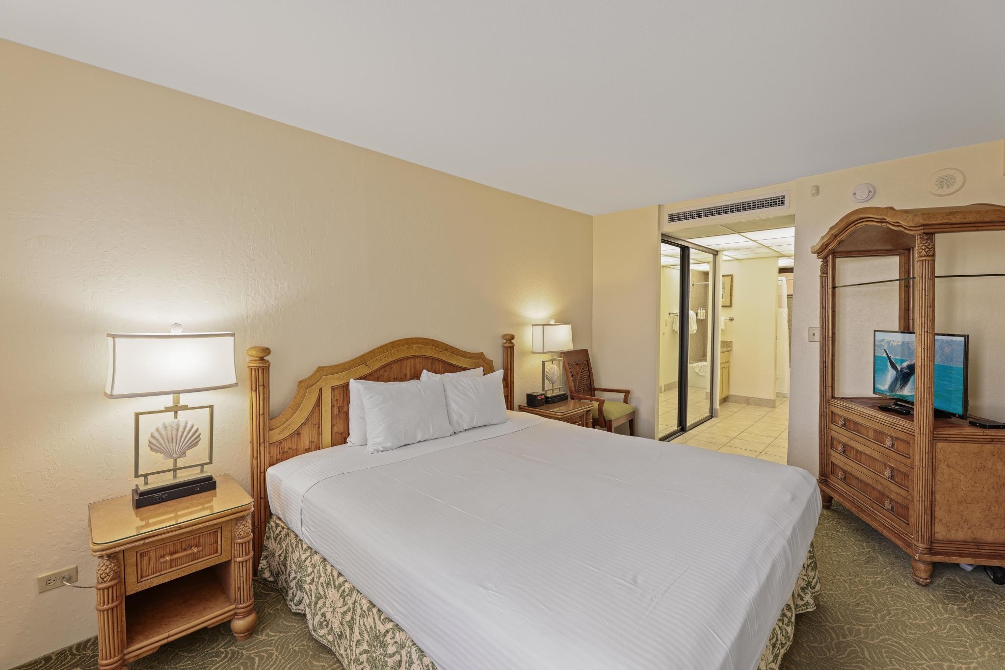 3445 Lower Honoapiilani Road, Unit 727 Lahaina, HI 96761 - Photo 19 of 42 a bedroom with a bed and a flat tv screen on dresser