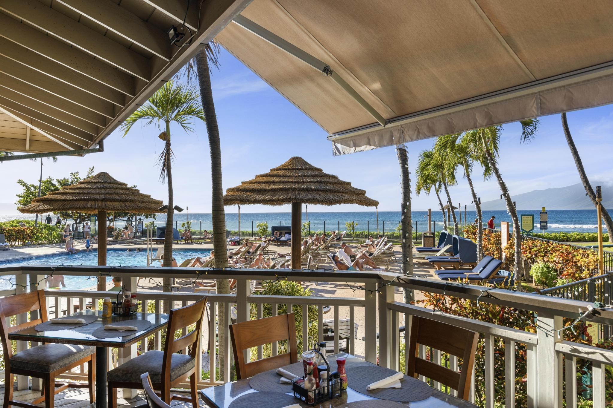 3445 Lower Honoapiilani Road, Unit 727 Lahaina, HI 96761 - Photo 38 of 42 a view of a patio with a table and chairs under an umbrella