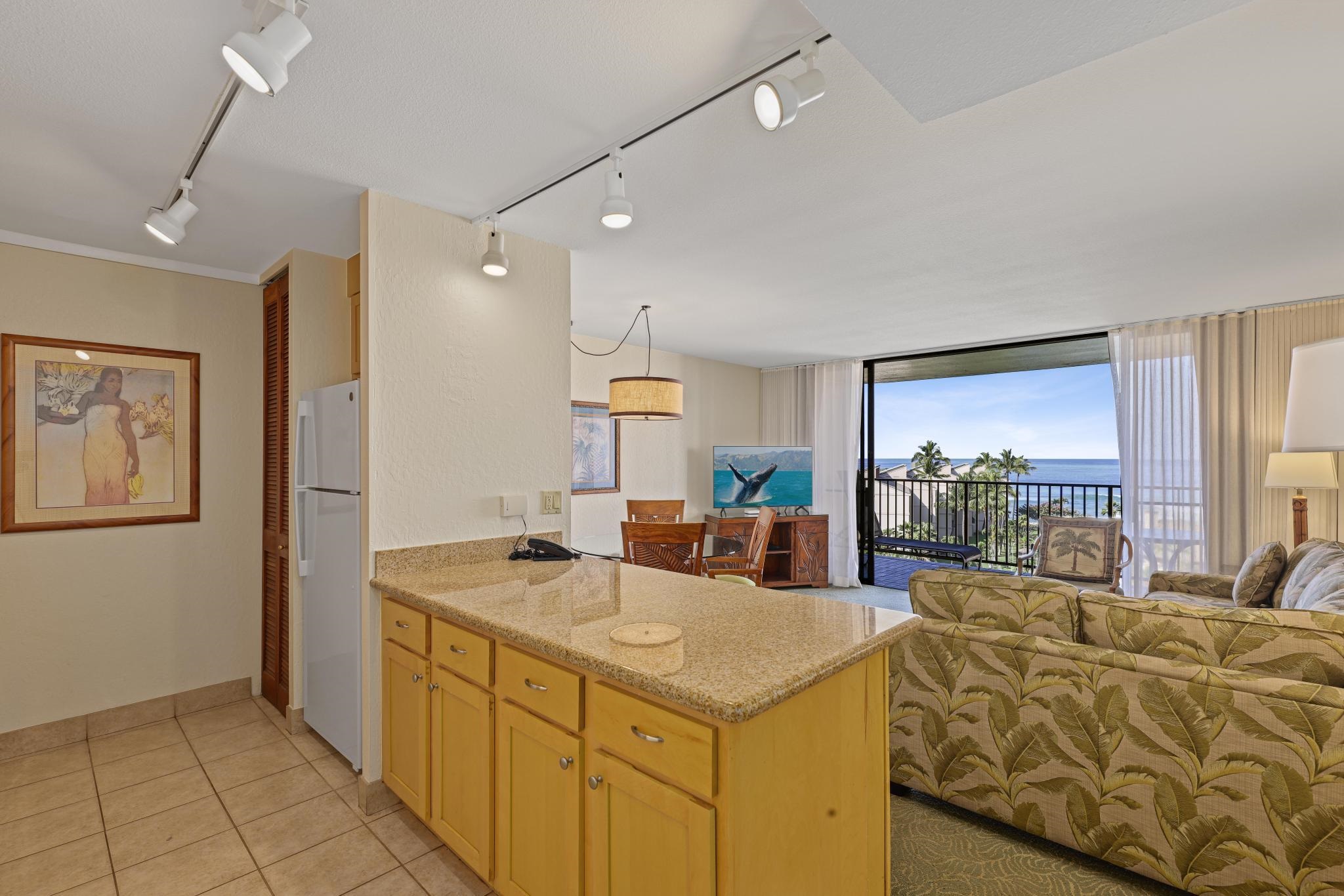 3445 Lower Honoapiilani Road, Unit 727 Lahaina, HI 96761 - Photo 9 of 42 a kitchen with stainless steel appliances kitchen island granite countertop a sink and a refrigerator
