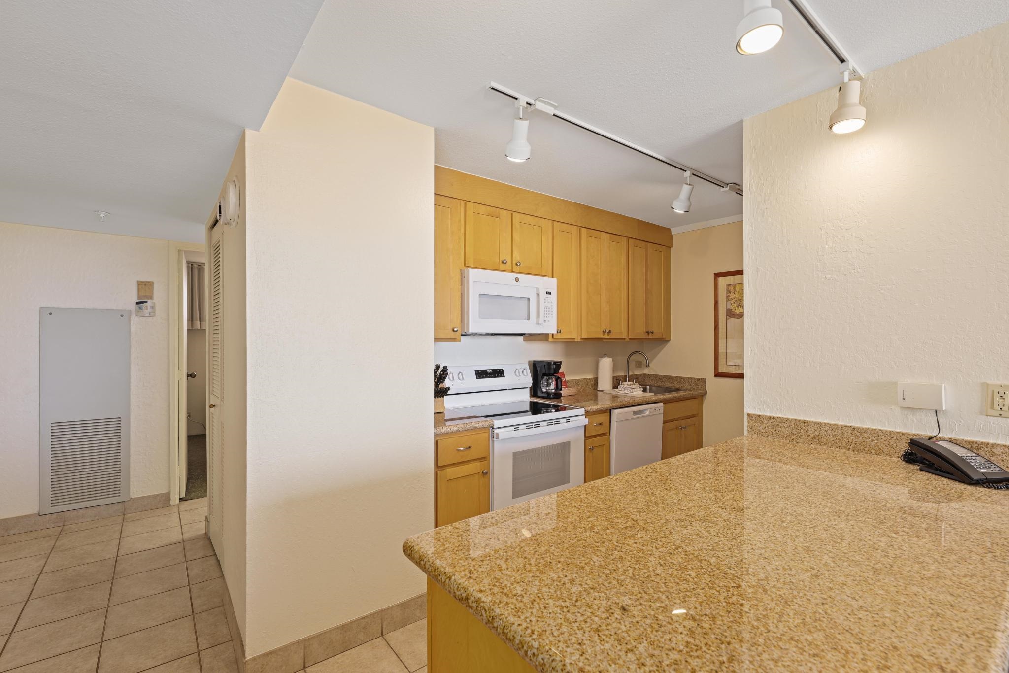 3445 Lower Honoapiilani Road, Unit 727 Lahaina, HI 96761 - Photo 10 of 42 a kitchen with a stove a refrigerator and a sink