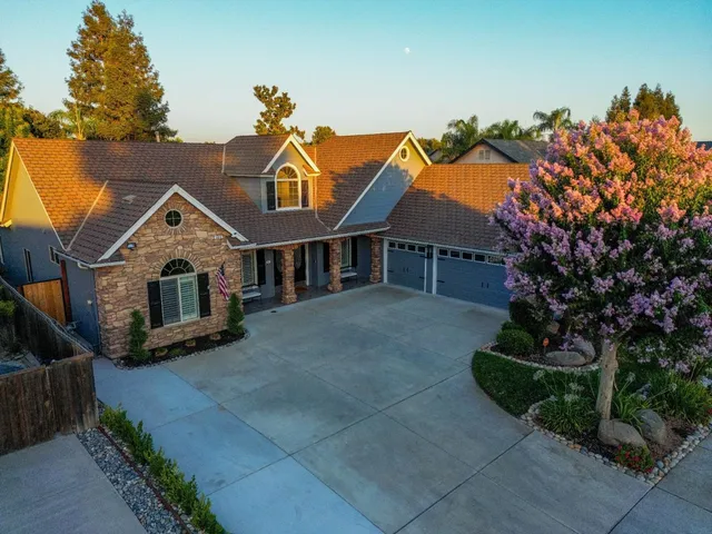 a view of a house with a yard and potted plants