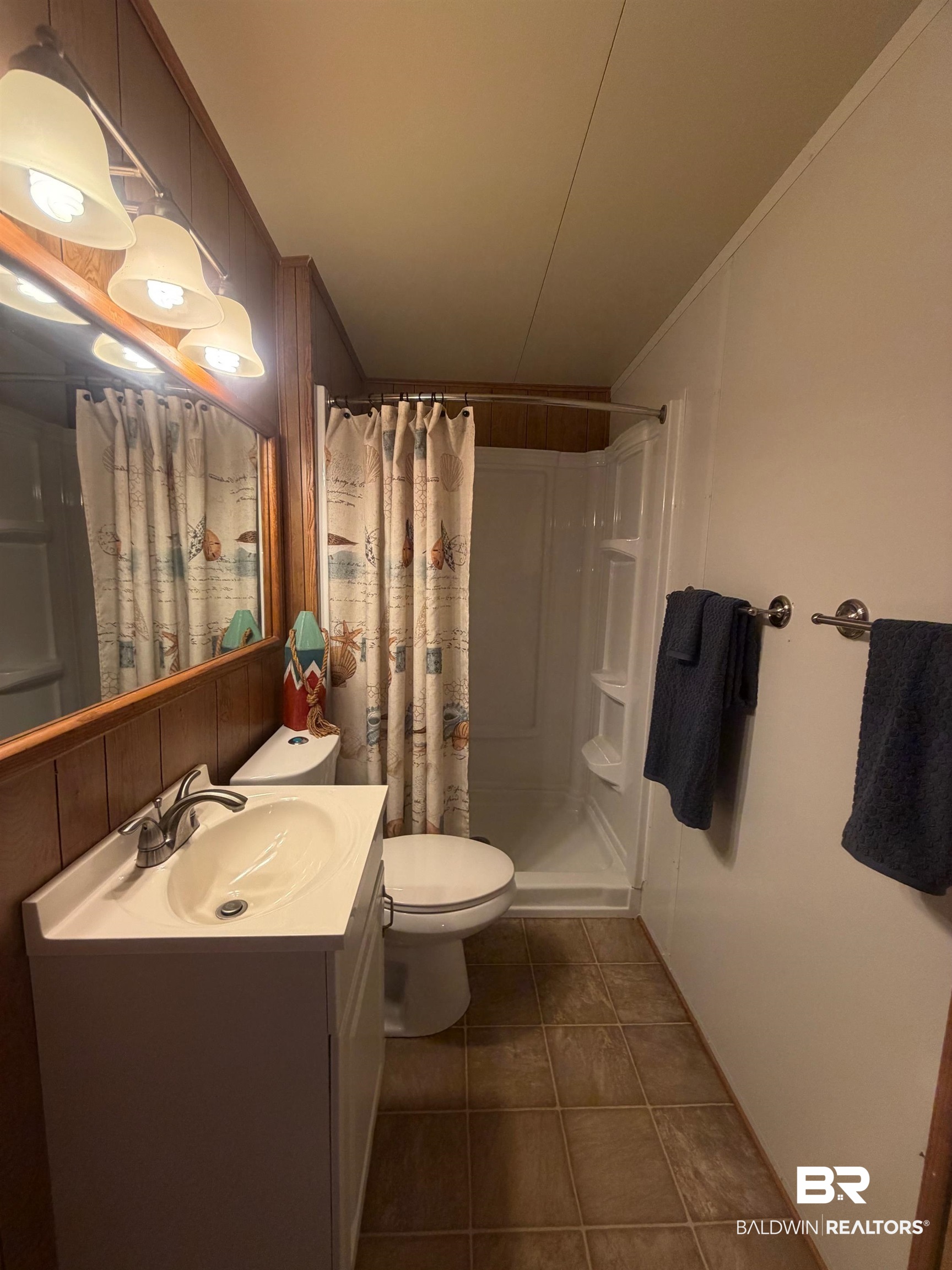 685 Escambia Loop Lillian, AL 36549 - Photo 15 of 43 Full bath featuring vanity, a shower stall, ornamental molding, and dark tile patterned floors