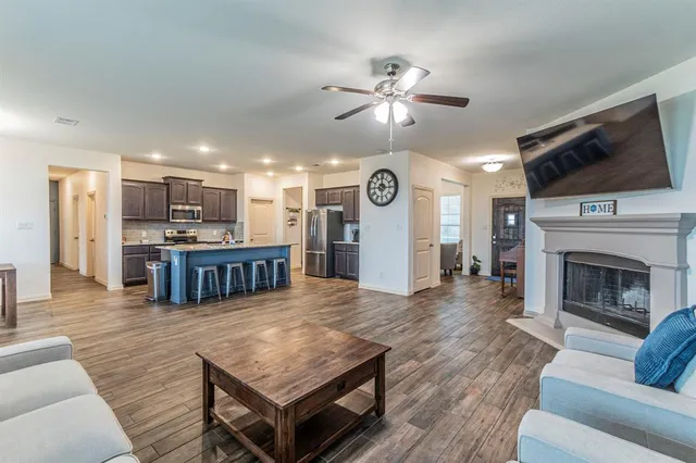 a kitchen with kitchen island granite countertop wooden floors and wooden cabinets