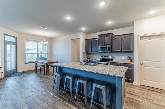 a kitchen with stainless steel appliances granite countertop a stove refrigerator sink microwave and cabinets