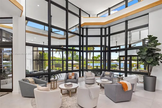a very nice looking living room with a large window and potted plants