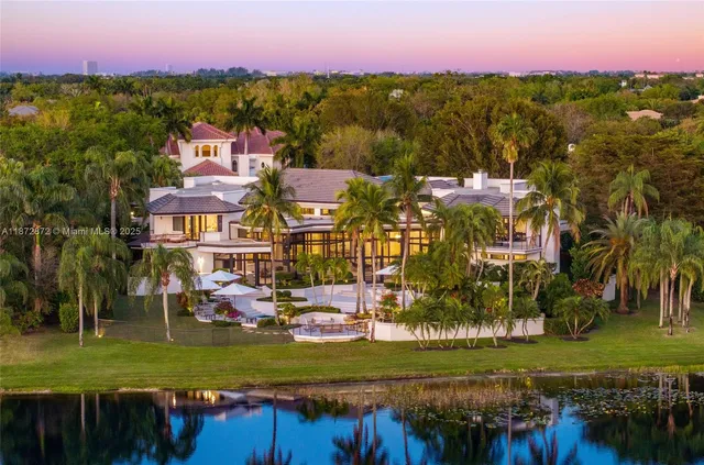 an aerial view of residential houses with outdoor space and lake view