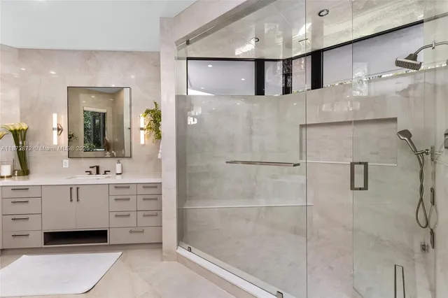 a bathroom with a tub shower sink and mirror