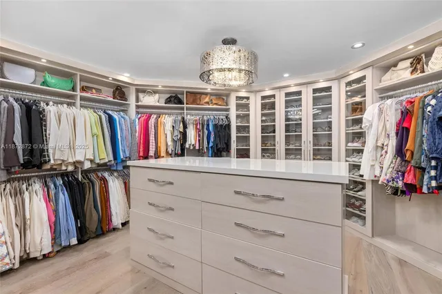 a view of walk in closet with clothes and shoes