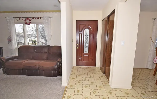 a living room with a couch and a dresser next to a window