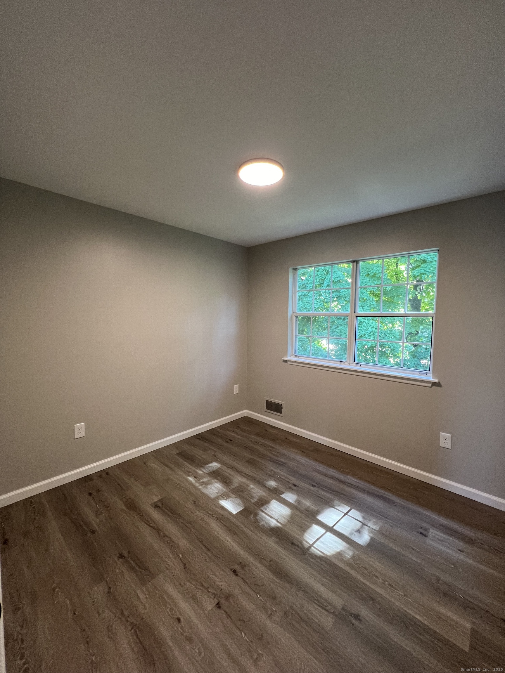 111-113 Sunset Avenue Meriden, CT 06450 - Photo 8 of 25 a view of an empty room with wooden floor and a window