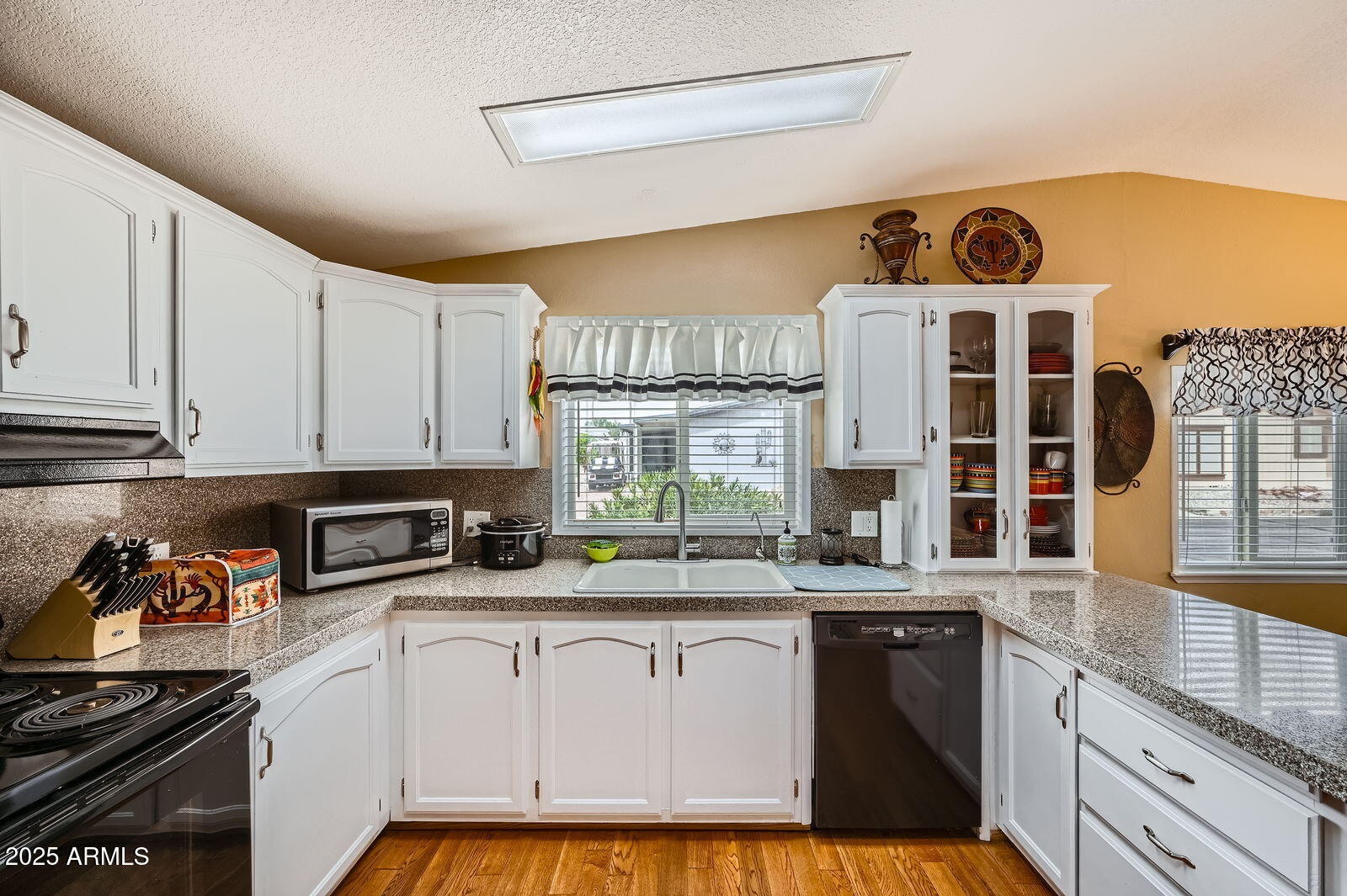 2400 East Baseline Avenue, Unit 94 Apache Junction, AZ 85119 - Photo 11 of 29 a kitchen with granite countertop a stove a sink and dishwasher wooden cabinets with granite countertops