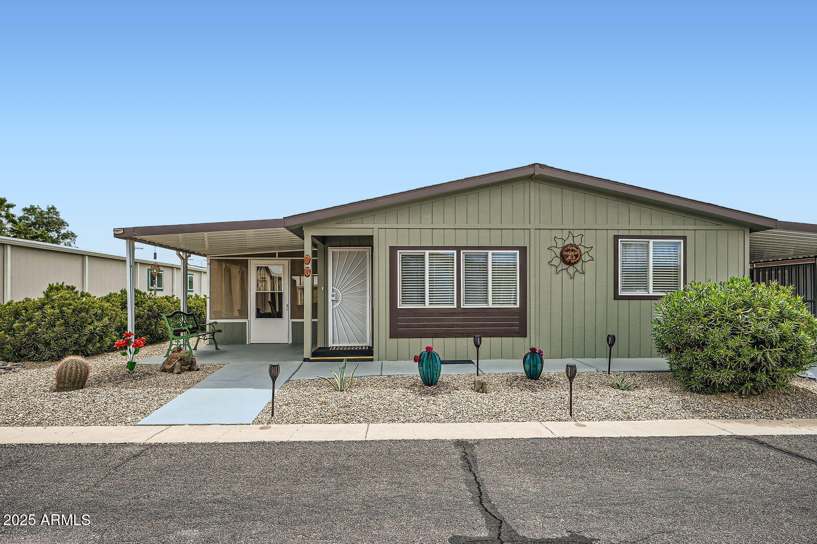 2400 East Baseline Avenue, Unit 94 Apache Junction, AZ 85119 - Photo 2 of 29 a front view of a house with a yard and plants