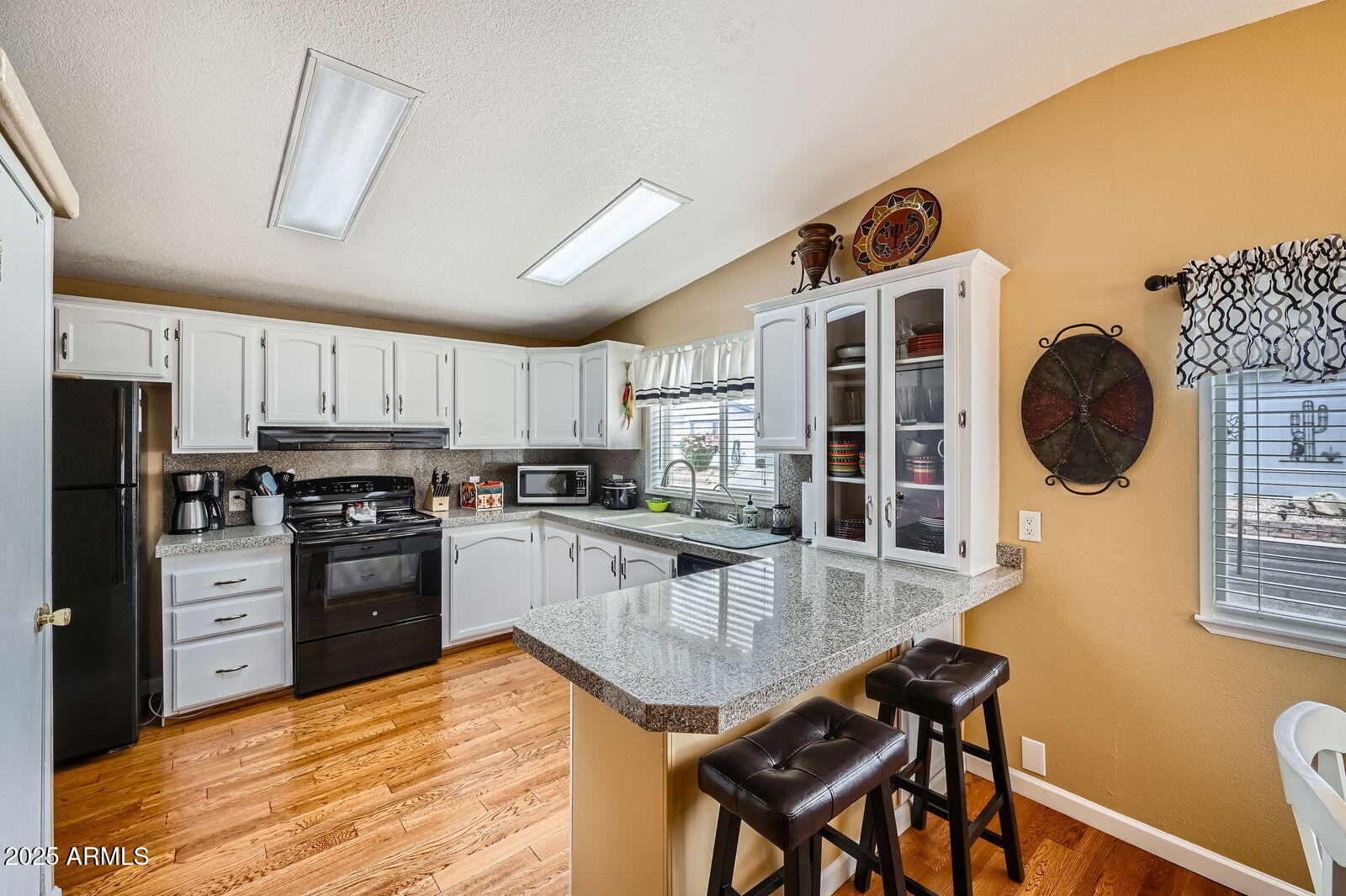 2400 East Baseline Avenue, Unit 94 Apache Junction, AZ 85119 - Photo 8 of 29 a kitchen with stainless steel appliances granite countertop a stove refrigerator a sink dishwasher with a dining table and chairs